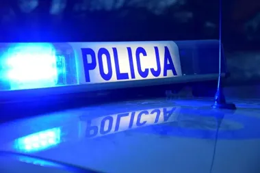 Nocne ujęcie błękitnego światła policyjnego sygnału świetlnego z napisem „POLICJA” na dachu radiowozu.